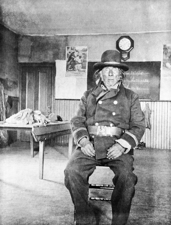 Original title:  Chiniki, head chief of the Stoneys, in classroom at Morley mission, Alberta. Date: [ca. 1896-1906]. Photographer/Illustrator: Walsh, Margaret Ann, Morley, Alberta. Image courtesy of Glenbow Museum, Calgary, Alberta.