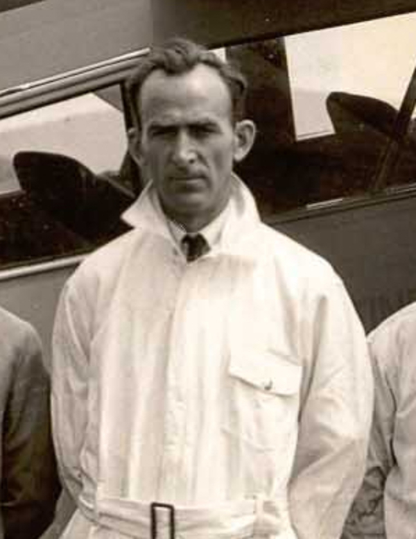 Original title:  Hervé St-Martin (4e de la droite) et le personnel de la Continental Aero Corporation à St-Hubert en 1929, devant un avion de type Travel Air 6000. À noter le mât du R-100 à l’arrière, prêt pour la venue du célèbre dirigeable un an plus tard.